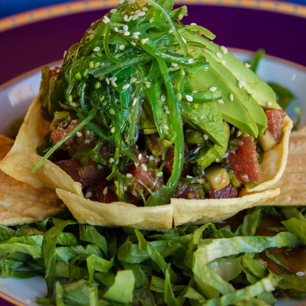 Sonrisa Grill's poke bowl with tuna, avocado, seaweed salad, and sesame seeds in a tortilla bowl.