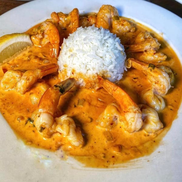 Sonrisa Grill's Mexican shrimp dish with rice and a lemon wedge in a rich orange sauce.